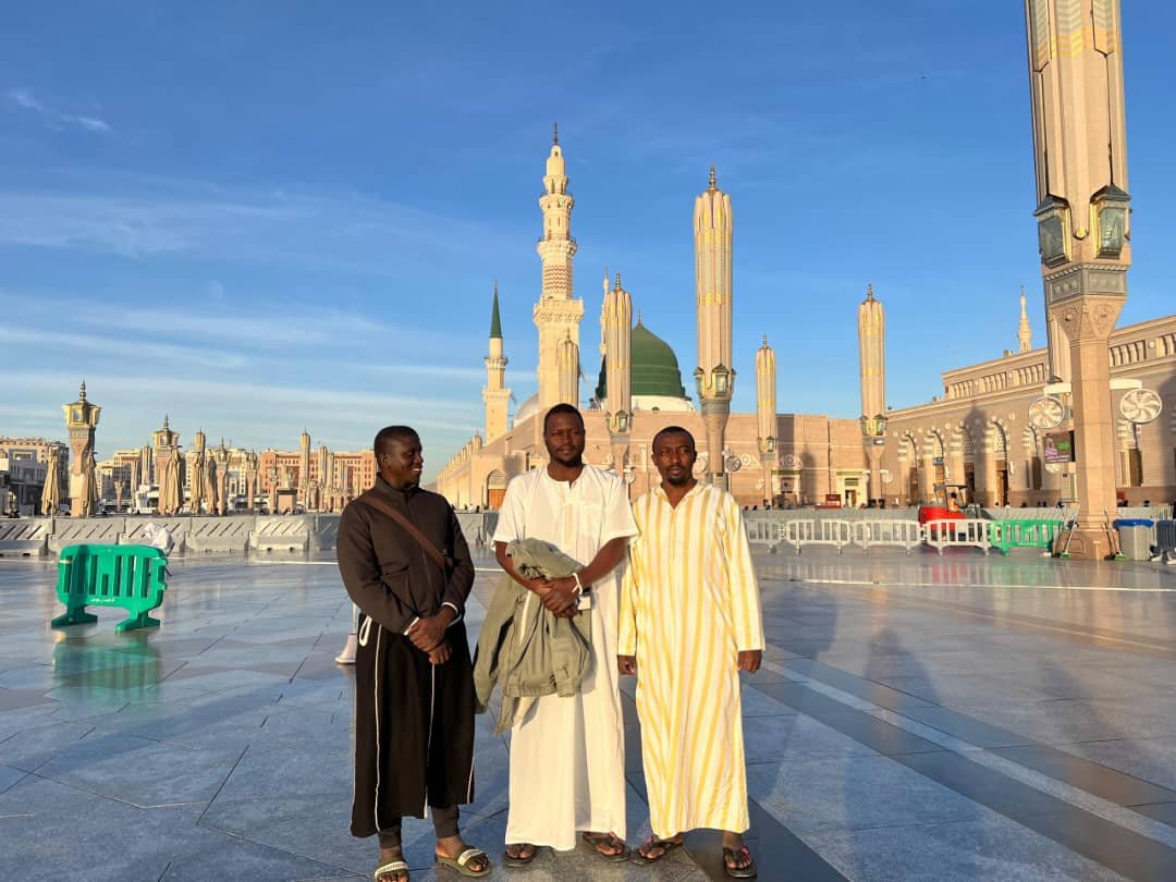 Pilgrims at Al-Masjid an-Nabawi Courtyard with Green Dome and Minarets in Madinah